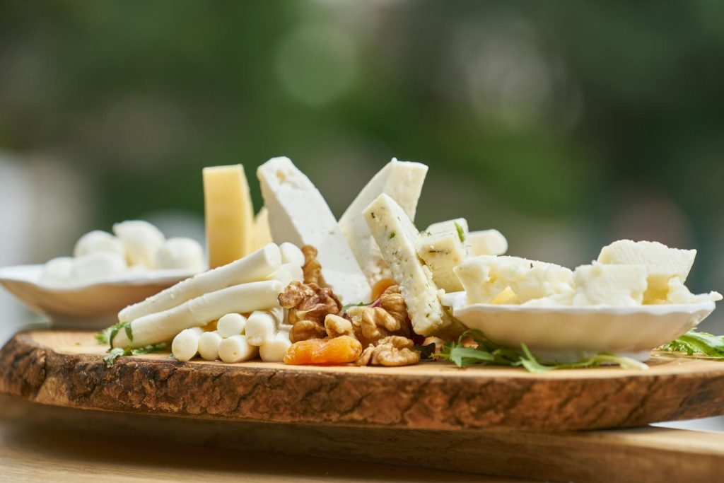 A delicious assortment of cheese and nuts on a rustic wooden board, perfect for appetizers.